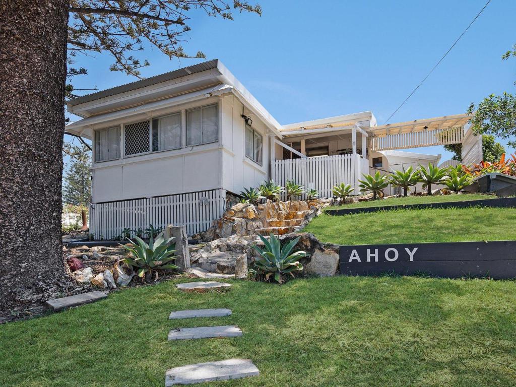 a house with a sign in front of it at Ahoy Cottage by Discover Stradbroke in Point Lookout
