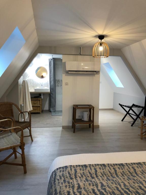 Camera mansardata con letto e sedia. di Le Moulin de Lassalle a Curemonte