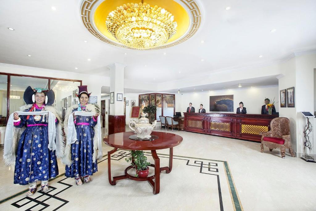 two women in a room with a table and a chandelier at The Grand Dragon Ladakh in Leh