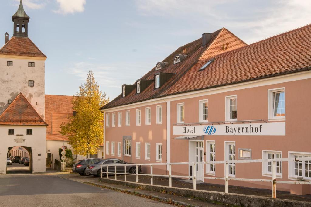 eine Straße in einer Stadt mit rosa Gebäuden und einer Kirche in der Unterkunft Hotel Bayernhof in Greding