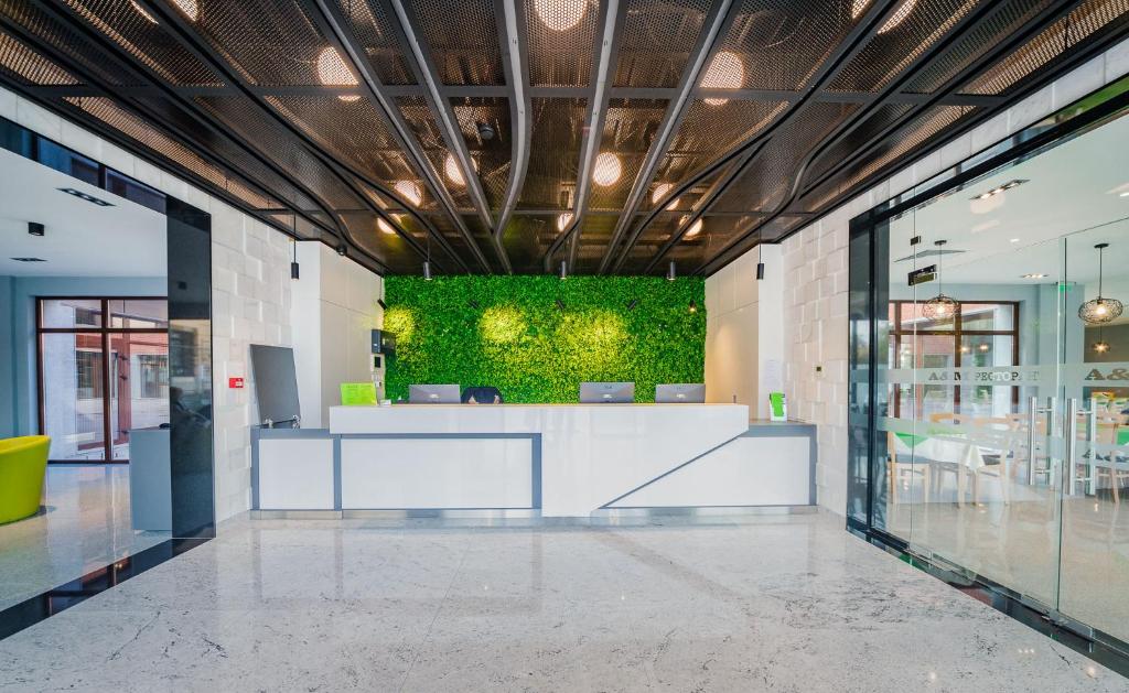 an office lobby with a green wall in the middle at A&M Hotel with free parking in Plovdiv
