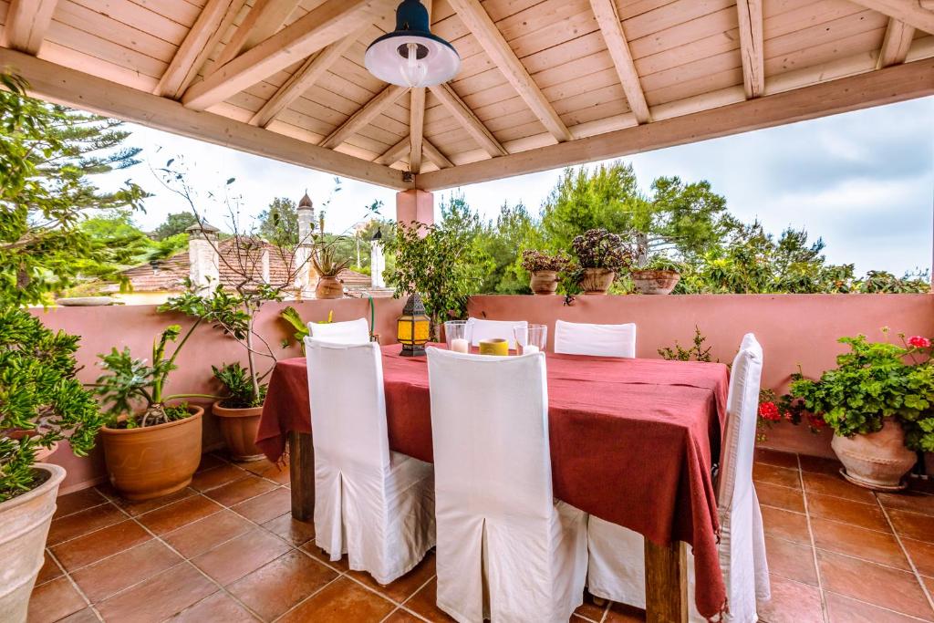 a patio with a table and chairs under a wooden pergola at Mastrogiannis Farm House in Armenádes