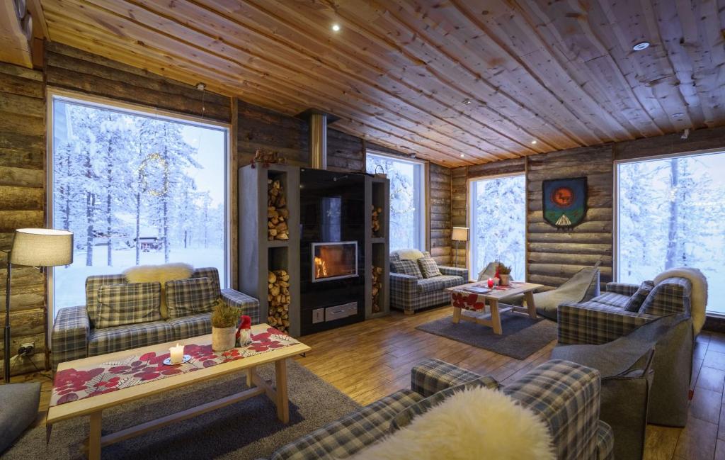 een woonkamer met banken en stoelen in een blokhut bij Wilderness Hotel Muotka & Igloos in Saariselkä