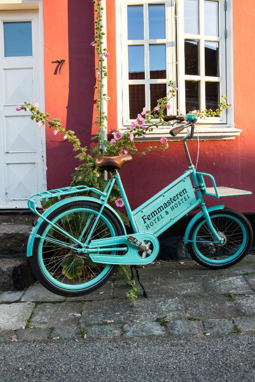 a blue bike parked in front of a building at Femmasteren Hotel & Hostel in Marstal