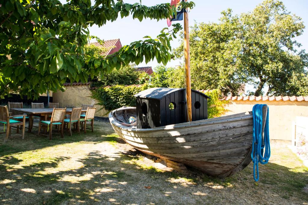 a wooden boat sitting on the grass in a yard at Femmasteren Hotel & Hostel in Marstal