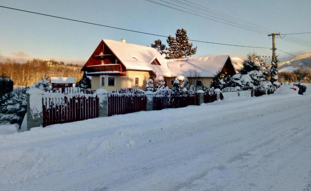 a house with a fence covered in snow at Privat Matej in Smrečany