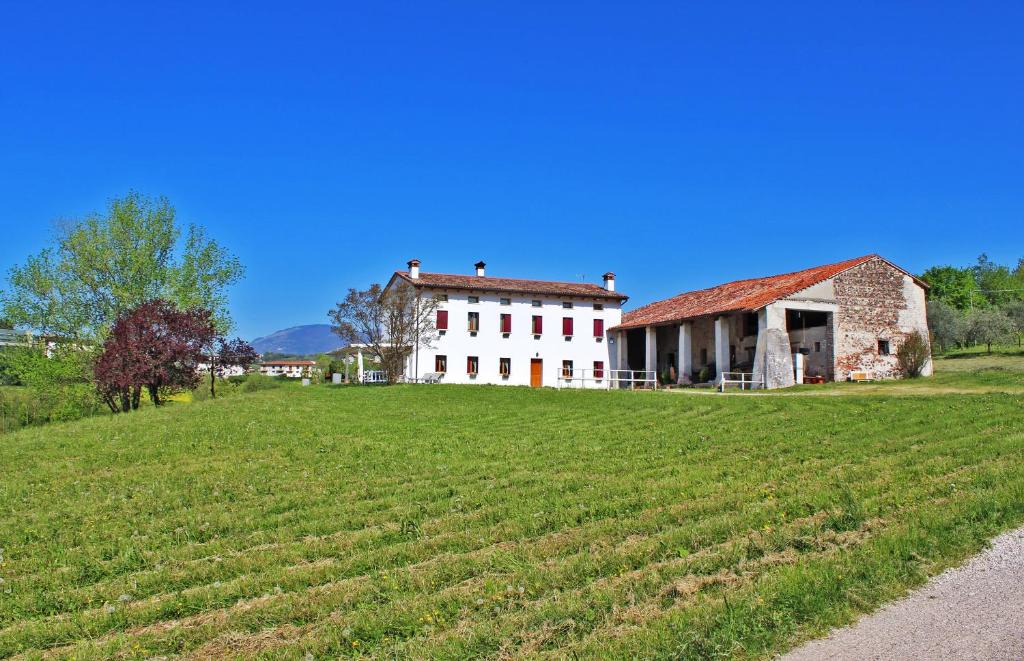 an old house on a grassy hill next to a field at Agriturismo Vecio Portico in Marostica