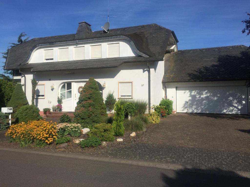 una casa blanca con un jardín delante de ella en Ferienwohnung Hetzerath, en Hetzerath