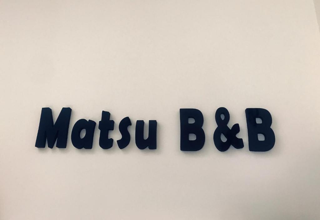 een bord op een muur dat métu bibliografie leest bij Matsu B&B in Nangan