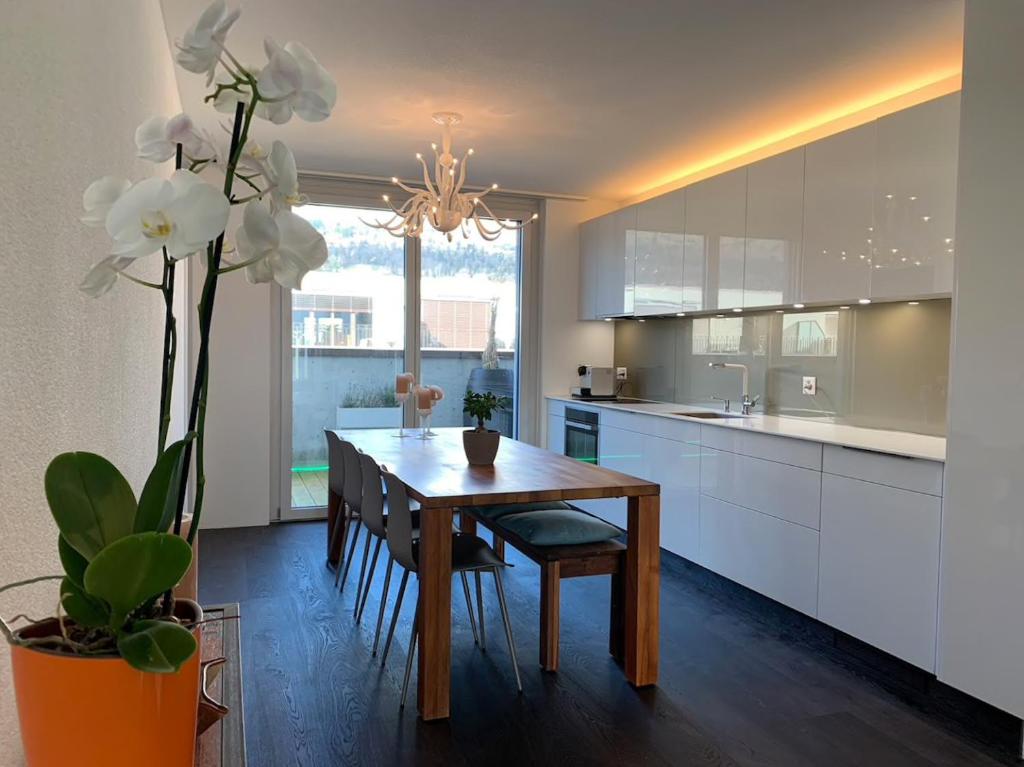 a kitchen with a wooden table and white cabinets at Central & Elegant Room in Biel in Biel