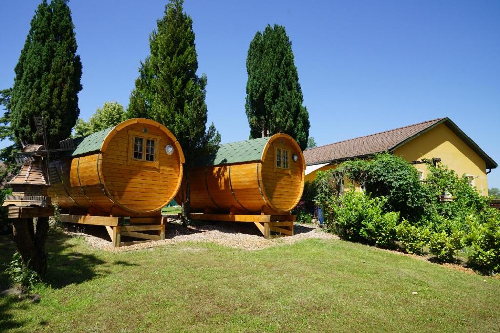 dwa okrągłe drewniane domy siedzące na dziedzińcu w obiekcie Barrel -schlafen im Fass w mieście Gorleben