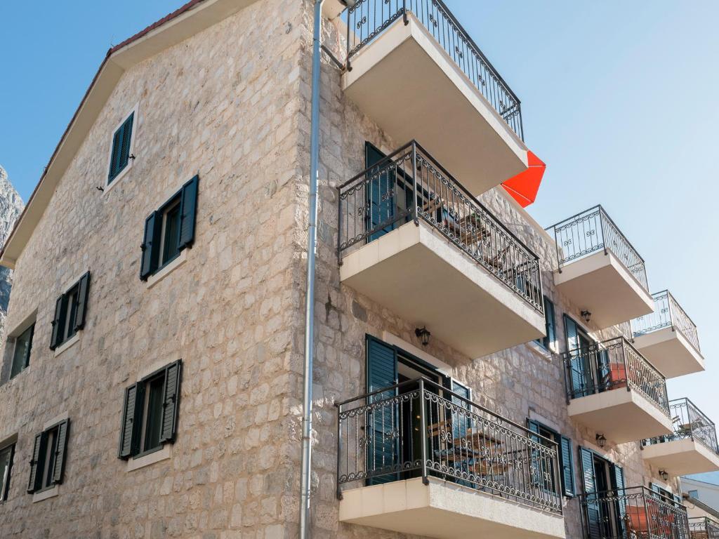 un edificio con balconi e bandiera rossa di Apartments Windrose a Kotor (Cattaro)