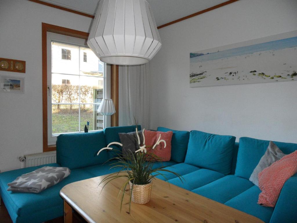 ヘリングスドルフにあるökologische Ferienanlageのリビングルーム(青いソファ、テーブル付)