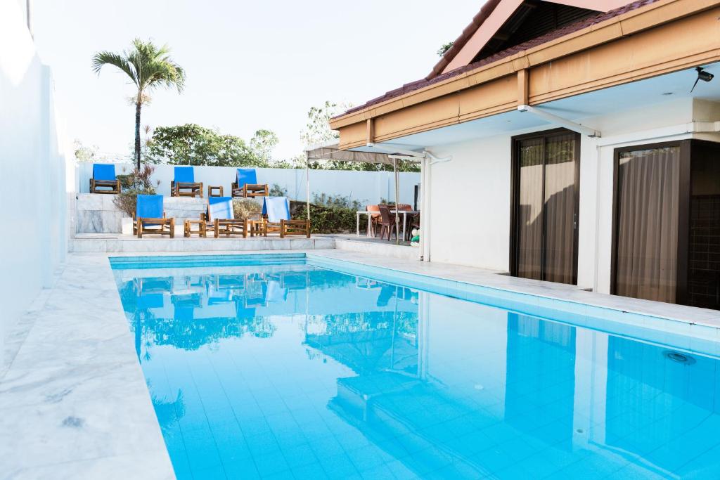a swimming pool in front of a house at Seaview Hills Luxury Apartments & Rooms in Dauis
