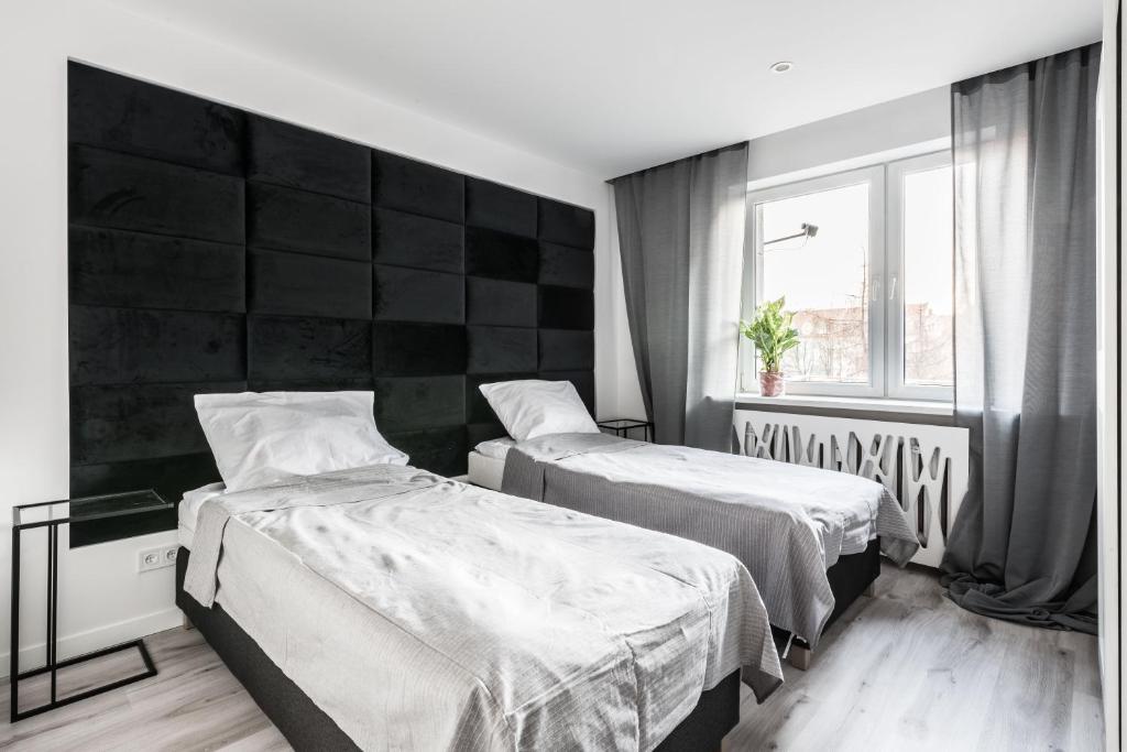 sypialnia z 2 łóżkami i oknem w obiekcie Theatre Apartment - Apartament przy Rynku w Głogowie w Głogowie