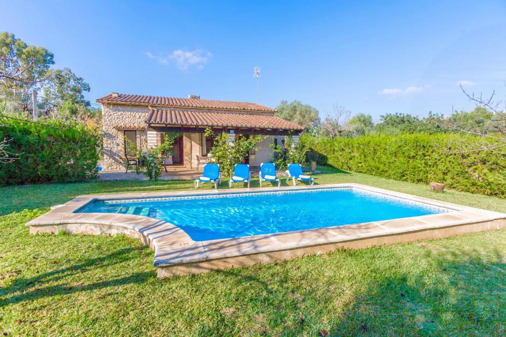 a swimming pool with chairs and a house at Villa Totxa in Pollença