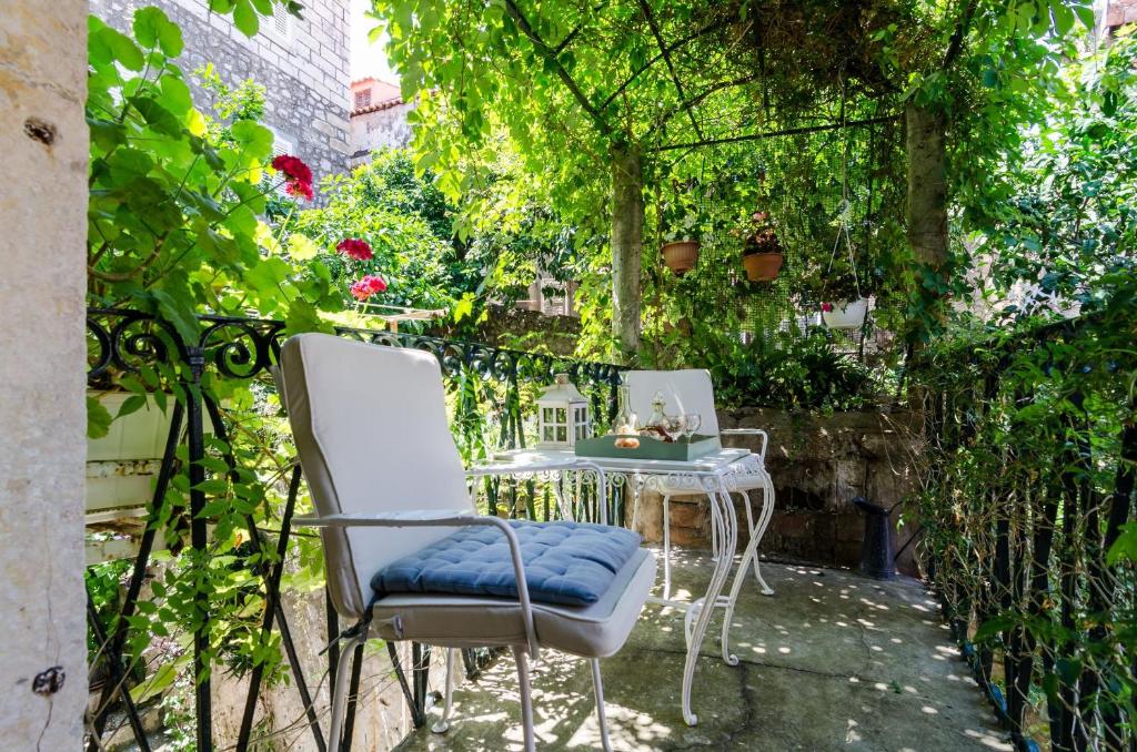 um pátio com cadeiras, uma mesa e videiras em Apartment Taura em Dubrovnik