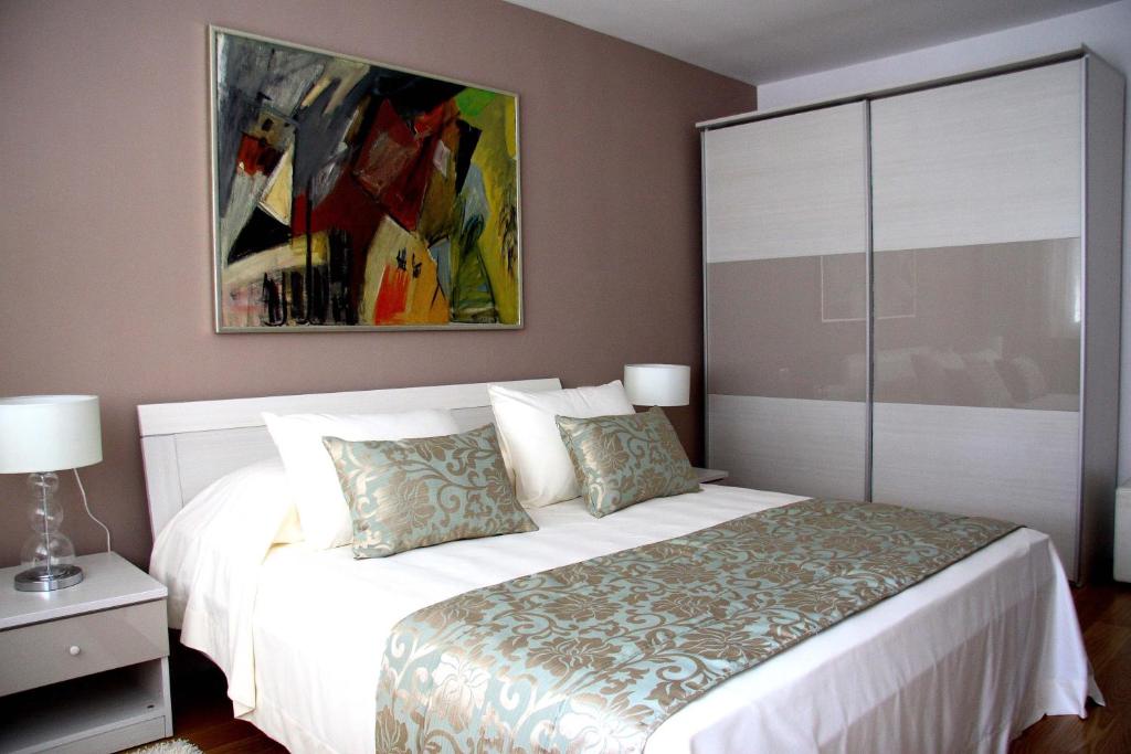 - une chambre avec un lit blanc et une peinture murale dans l'établissement Apartment Akvarel, à Split