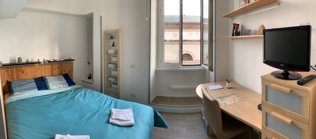 a bedroom with a bed and a desk and a television at The Rica House in Rome