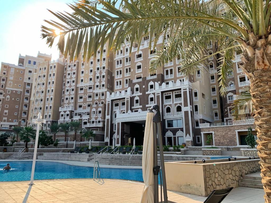 a hotel with a palm tree and a pool at Luxury Apartments at Balqis Residence in Dubai