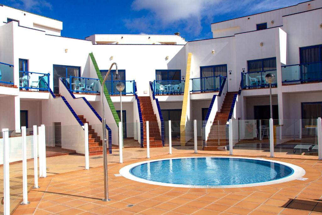 a building with a pool in the middle of a courtyard at TAO El Cotillo in El Cotillo