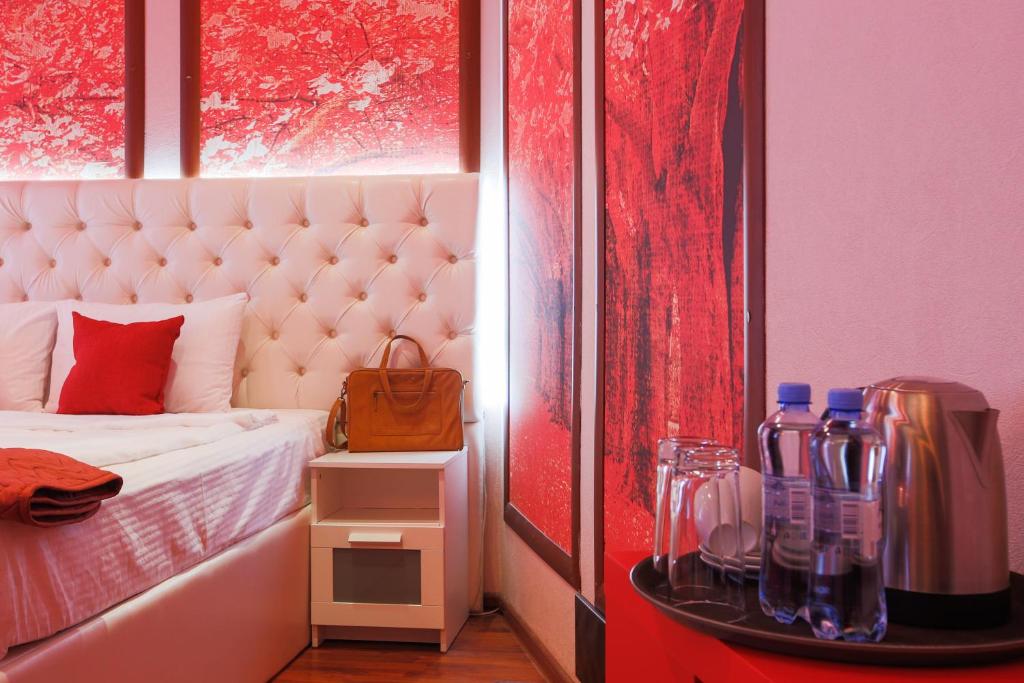 a bedroom with a bed with a red wall at Hotel Palitra in Ufa