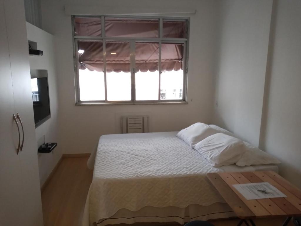 Habitación pequeña con cama y ventana en Studio Copacabana, en Río de Janeiro