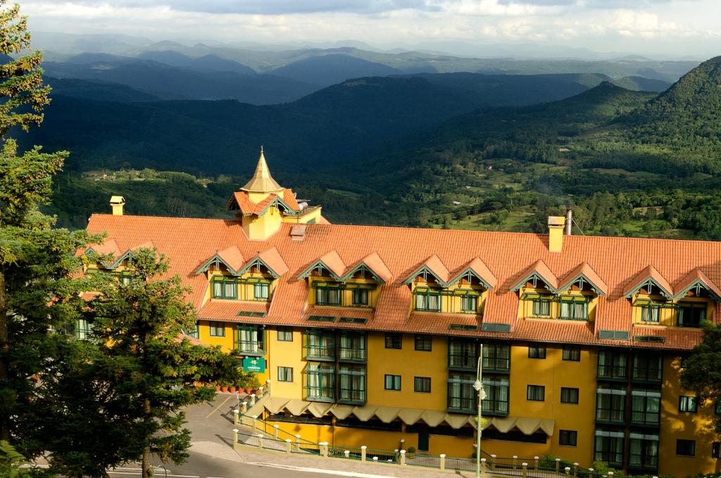 un grande edificio giallo con tetto rosso di Hotel Laghetto Toscana a Gramado