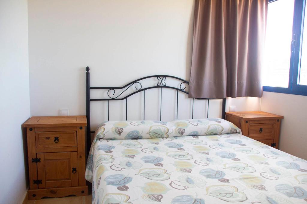 a bedroom with a bed and two dressers and a window at TAO El Cotillo in El Cotillo