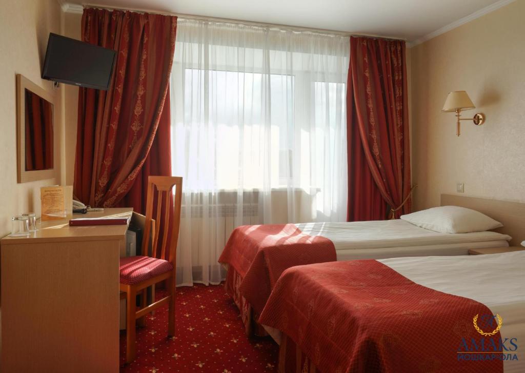 a hotel room with two beds and a window at AMAKS City Hotel in Yoshkar-Ola