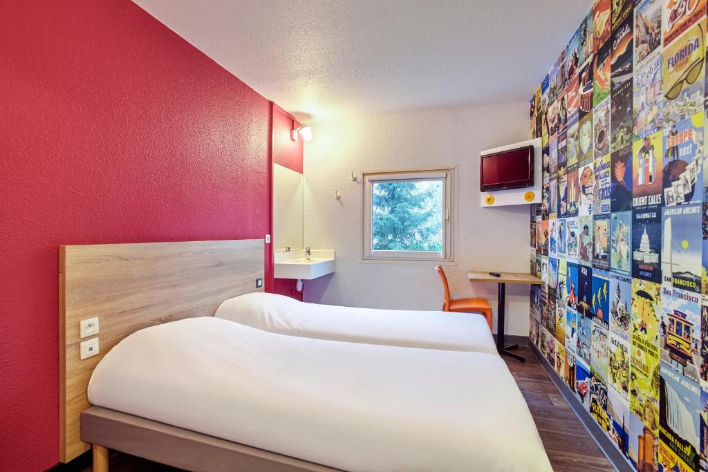 Habitación con 3 camas y pared roja. en hotelF1 Mulhouse Bâle Aéroport en Haberhaeuser