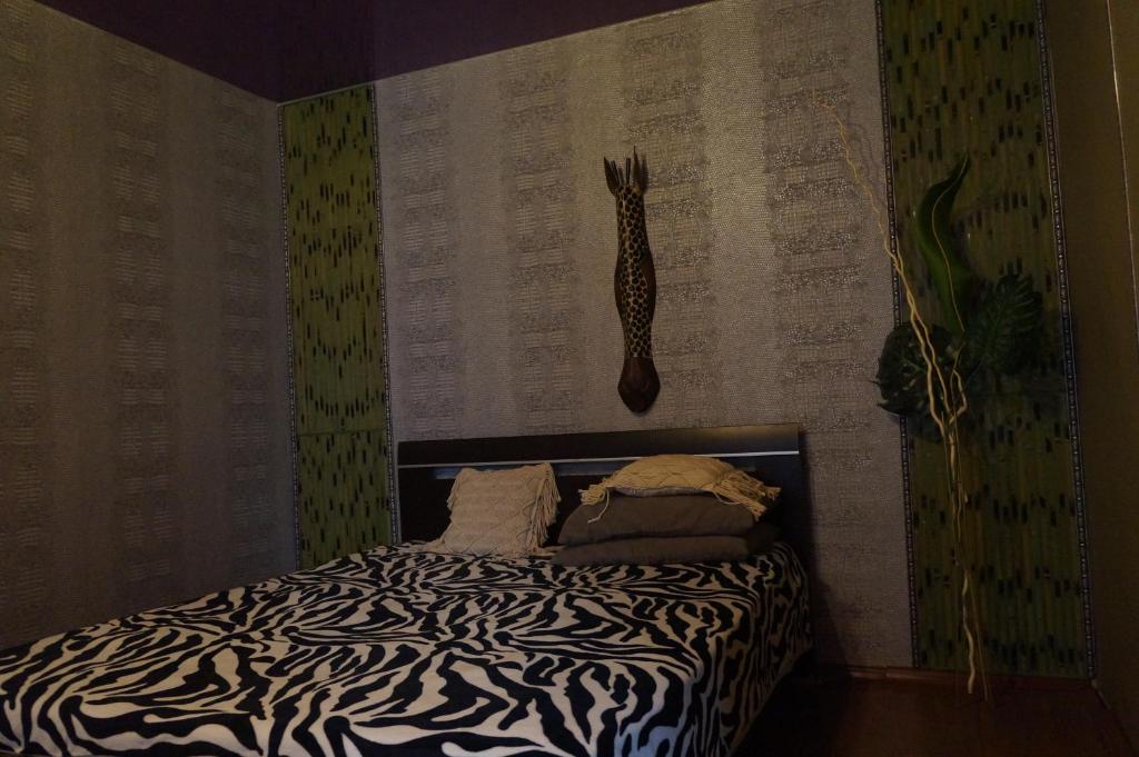 a bedroom with a bed with a zebra print wall at Always at home - Apartments №2 at Klimasenko 11 block 7 in Novokuznetsk