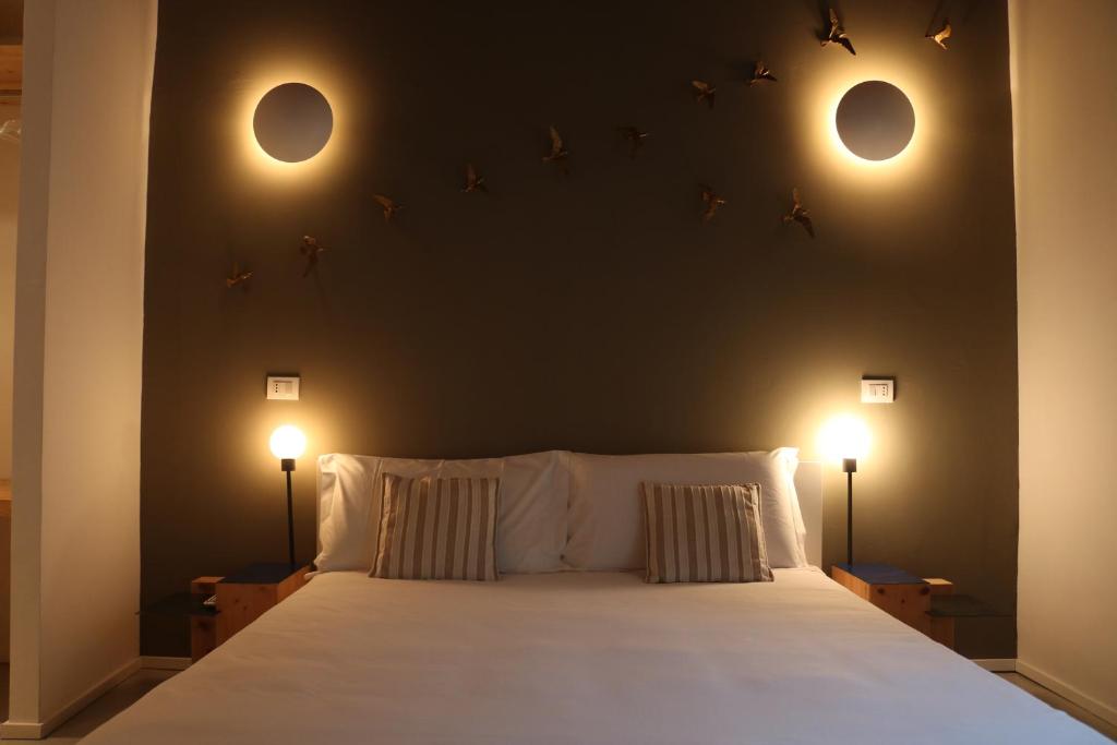 una camera da letto con un grande letto con due luci sul muro di New Fontana Rooms a Como