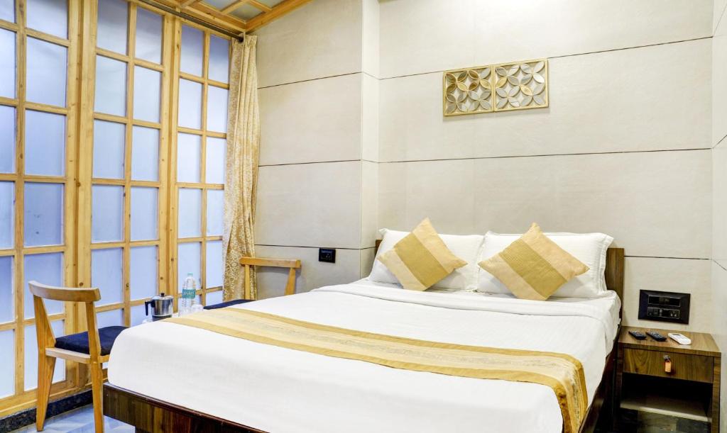 a bedroom with a bed and a large window at Hotel Rooms Dadar near Station in Mumbai