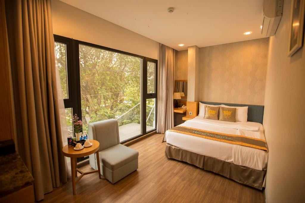 um quarto de hotel com uma cama e uma grande janela em The Blue Airport Hotel em Ho Chi Minh