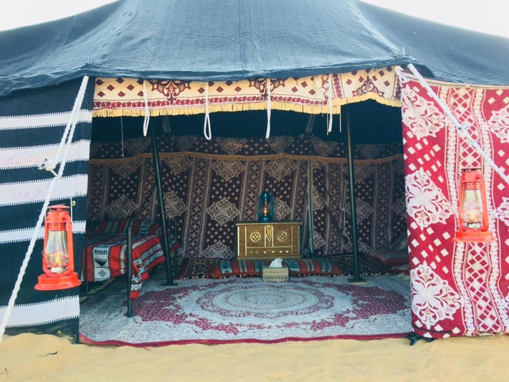 a tent with a table and a throne in it at Sultan Private Desert Camp in Bidiyah