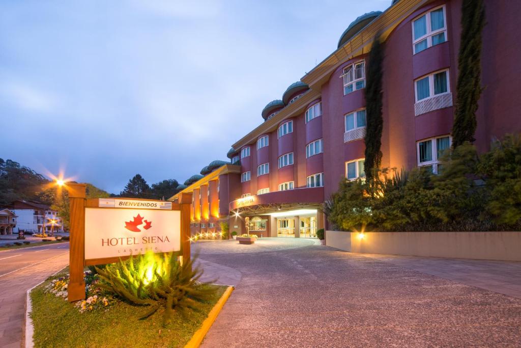 una señal de hotel frente a un edificio en Hotel Laghetto Siena Gramado, en Gramado