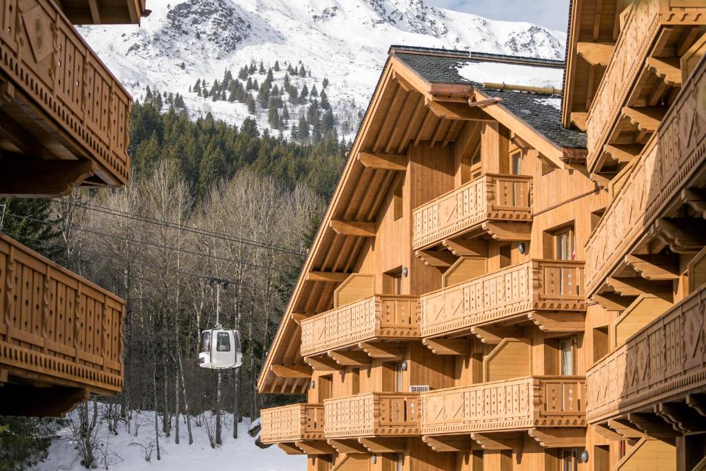 a building with wooden balconies and a ski lift at Residence l Hevana - maeva Home in Méribel