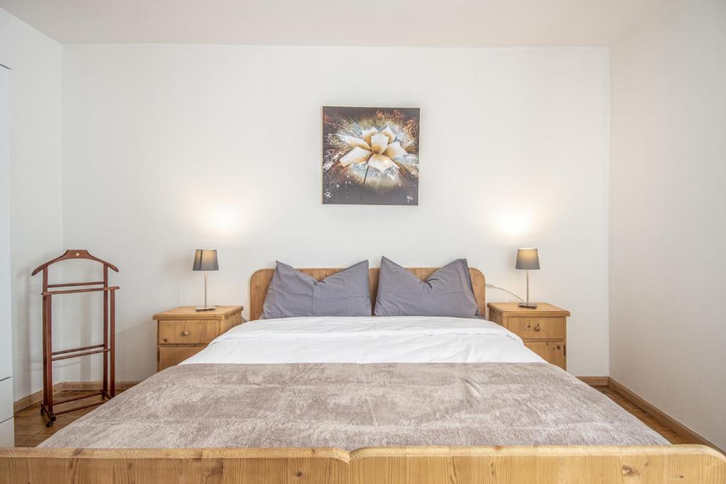una camera da letto con un grande letto con due comodini di Villa Noce 1 a Tesero