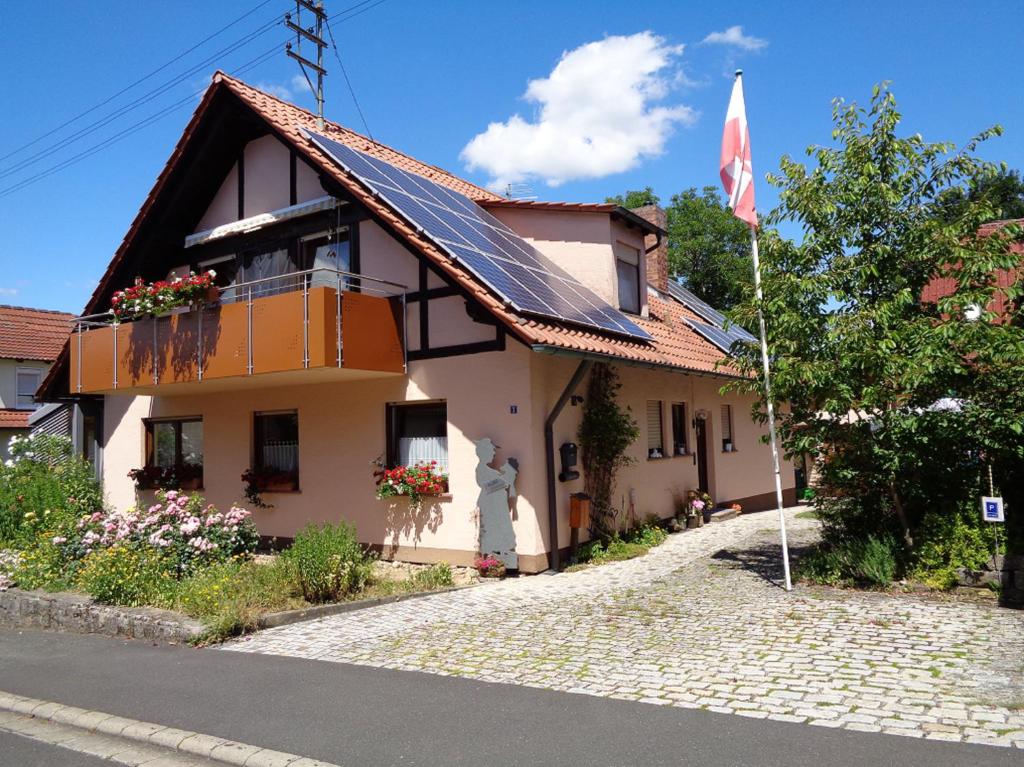 een huis met een vlag aan de kant van de weg bij Ferienwohnung Löber in Eußenheim