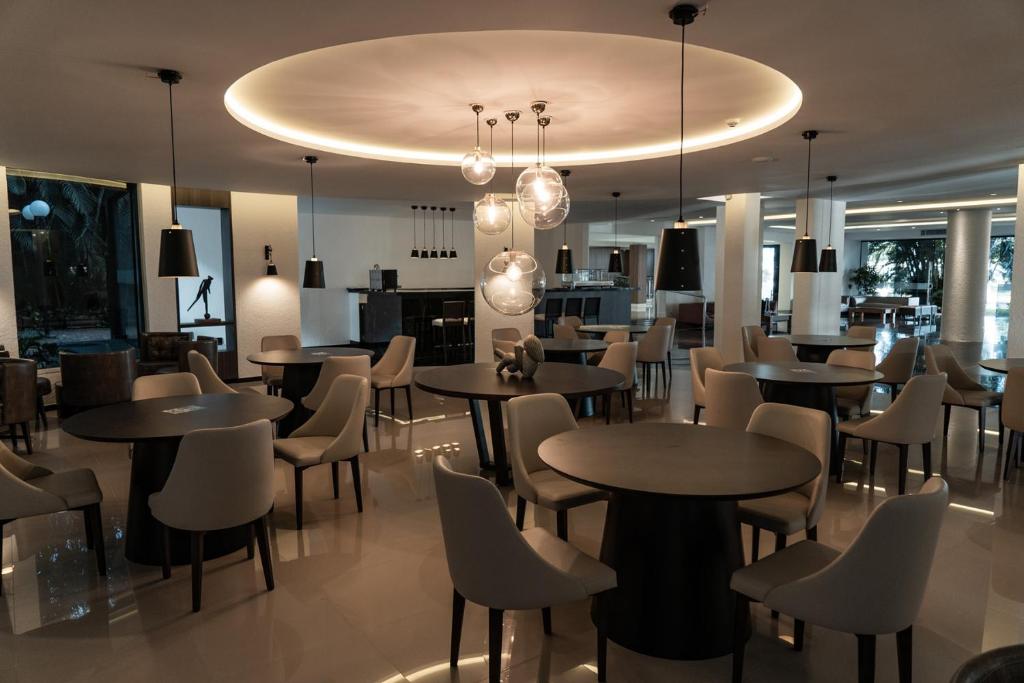 a restaurant with tables and chairs in a room at Rafain Palace Hotel & Convention Center in Foz do Iguaçu