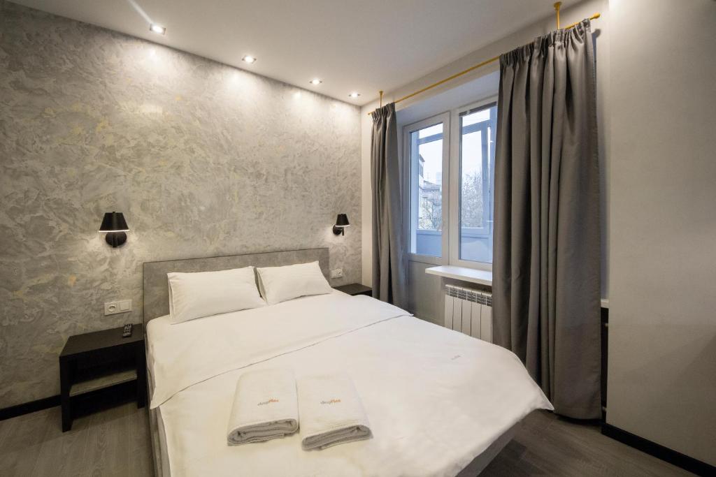 sypialnia z białym łóżkiem i oknem w obiekcie Modern Apartments on Baseina near Arena City w Kijowie