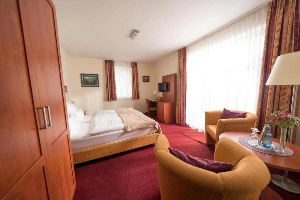 a hotel room with a bed and a desk and chairs at Hotel & Café Strandeck in Prerow