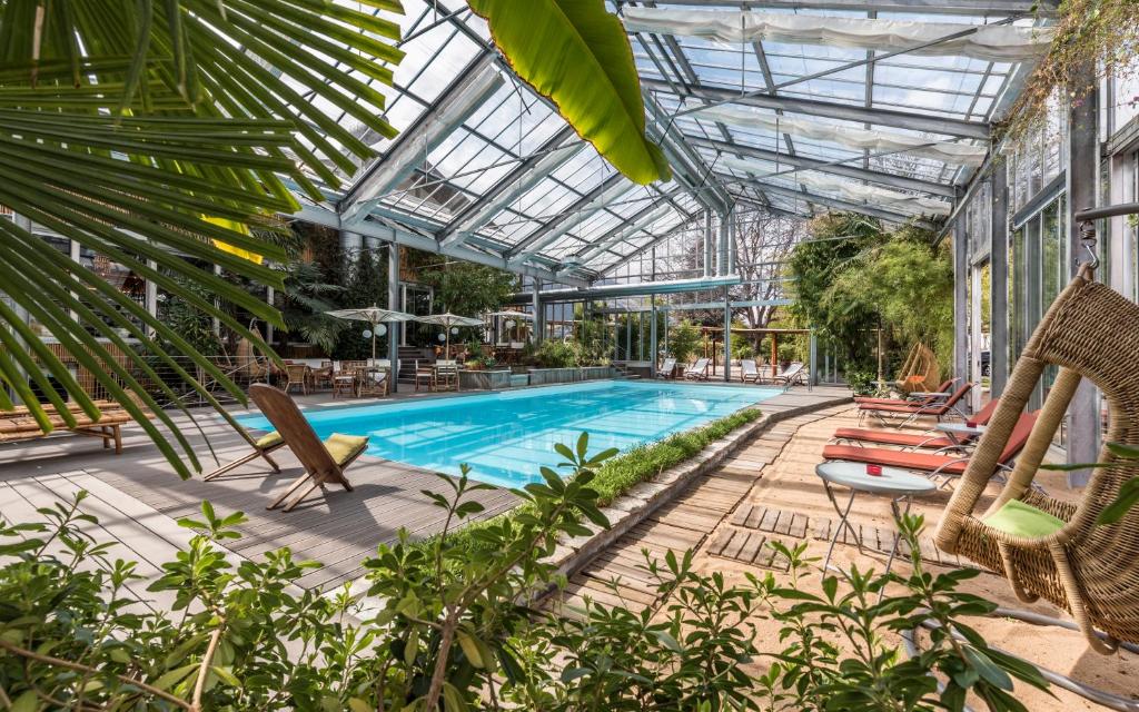 una piscina con sillas y un techo de cristal en Hotel Bamboo, en Coldrano