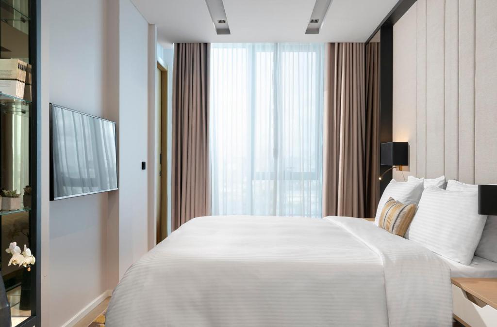 a bedroom with a large white bed and a window at WestSide Residences by Rotana in Istanbul