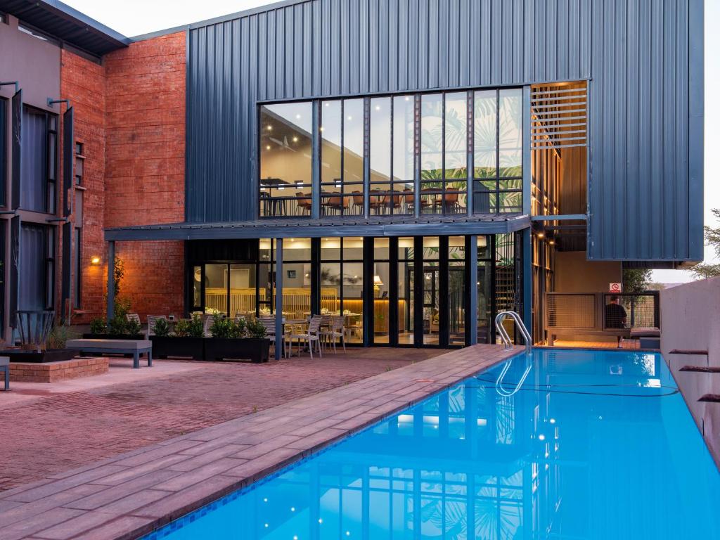 an external view of a house with a swimming pool at aha Kathu Hotel in Kathu