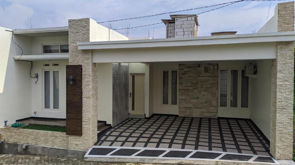 ein Haus mit einer Veranda und einem Gebäude in der Unterkunft Villa Dean in Batu