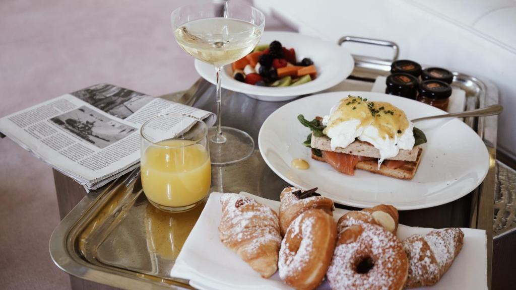 a tray with two plates of breakfast foods and a glass of wine at Hotel Palazzina Grassi in Venice