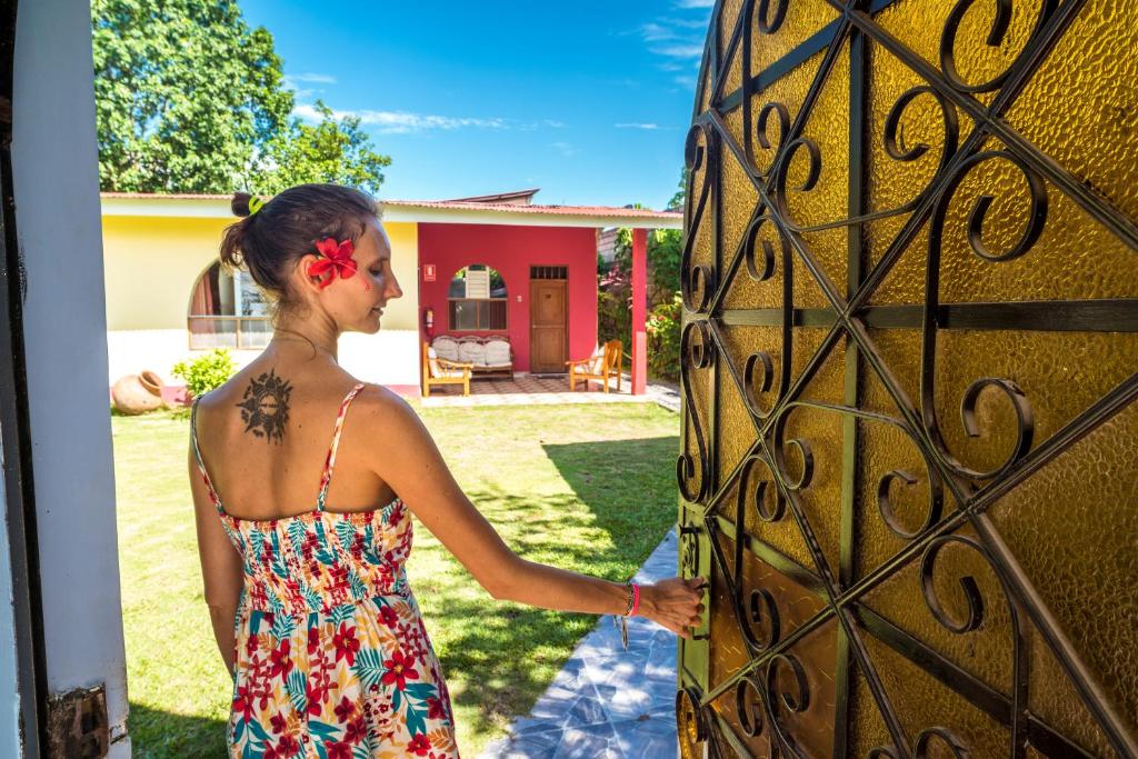 a woman in a dress unlocking a gate at Go-Inn Hotel in Tarapoto