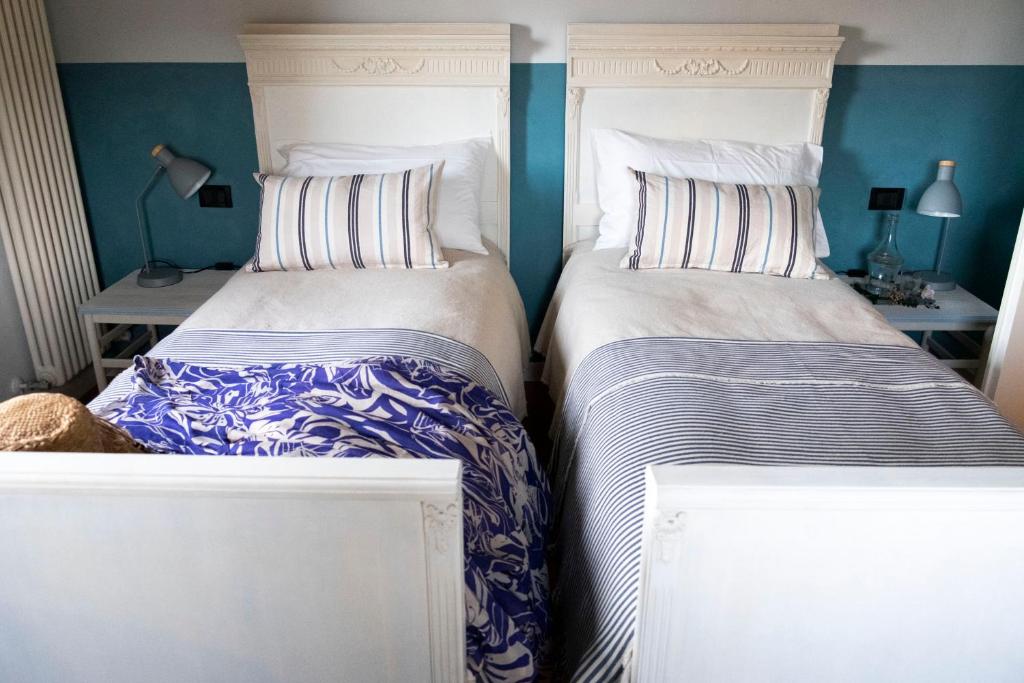 dwa łóżka siedzące obok siebie w sypialni w obiekcie La Porta Accanto B&B w mieście San Vito di Leguzzano